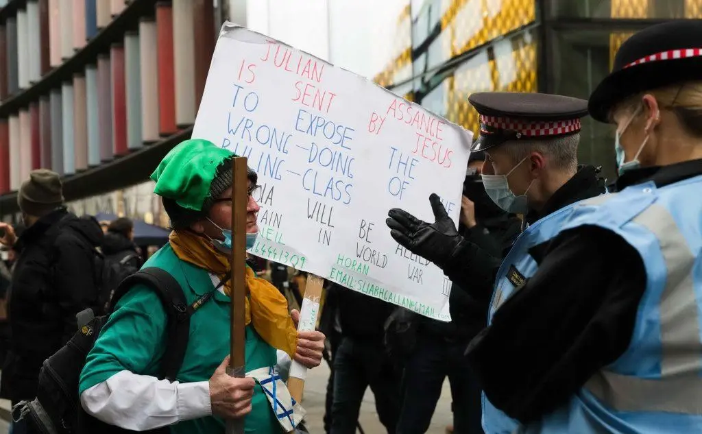 Un manifestante con un cartello parla con i poliziotti
