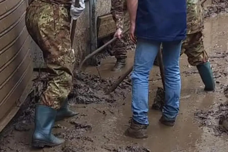 Al lavoro per sgomberare i detriti di un'alluvione  (L'Unione Sarda)
