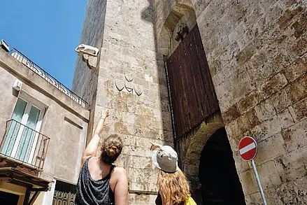 Cagliari, due turisti osservano la scultura dell’elefante che dà il nome alla torre (archivio L'Unione Sarda)