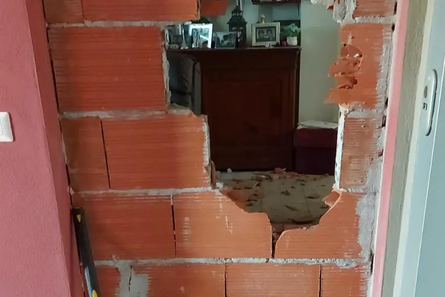 La parete della casa sfondata a colpi di mazza (Foto: Scano)
