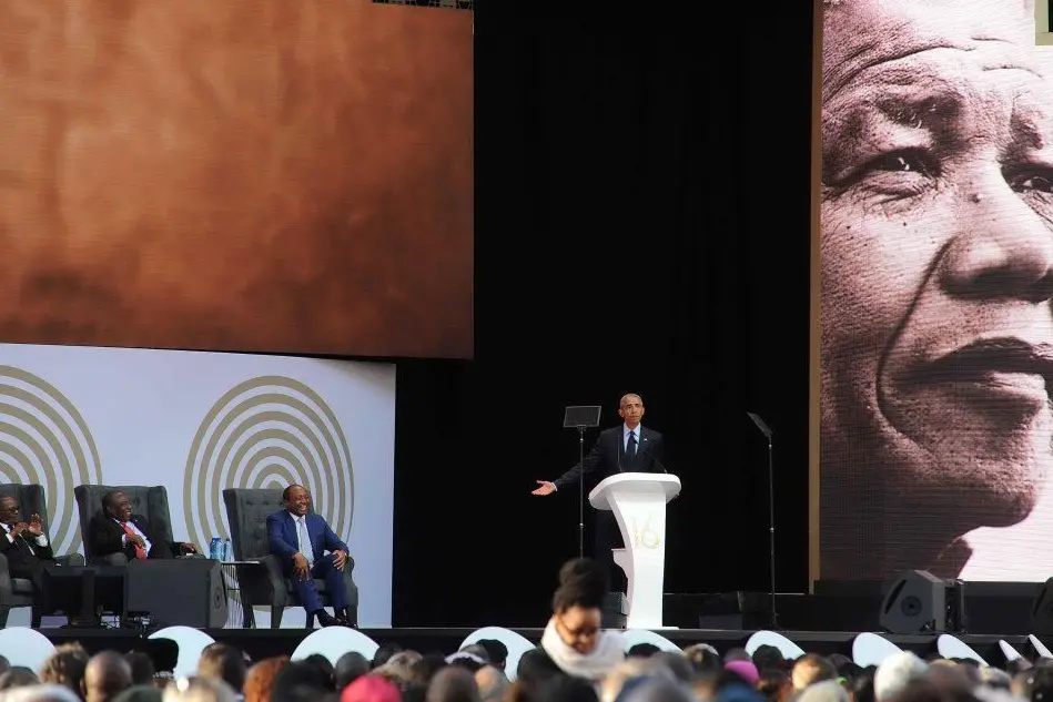 Barack Obama, al centro. Sullo sfondo, Nelson Mandela