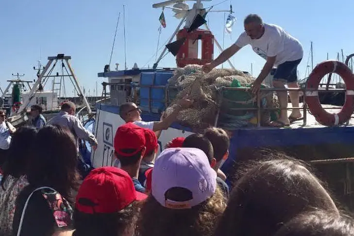 Un momento della pesca dei rifiuti a Porto Torres