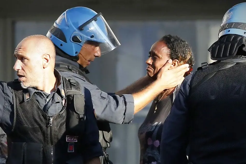 Un poliziotto consola una migrante: ecco la foto simbolo degli sgomberi a Roma