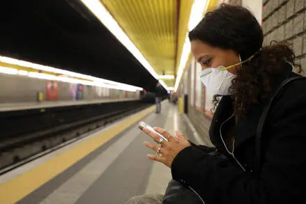 Una donna con la mascherina in metropolitana (Ansa)