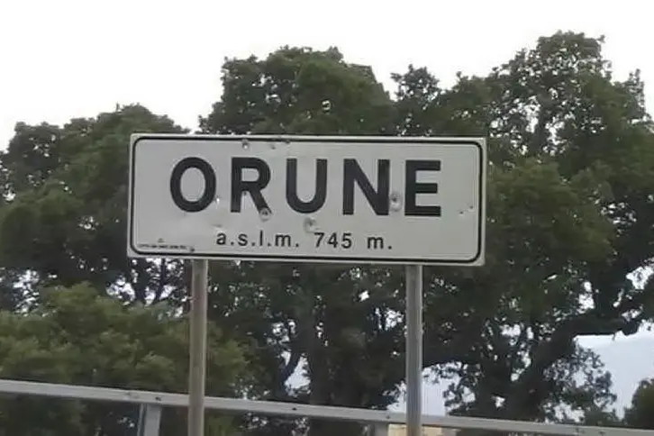 Un cartello perforato dai proiettili all'ingresso Orune