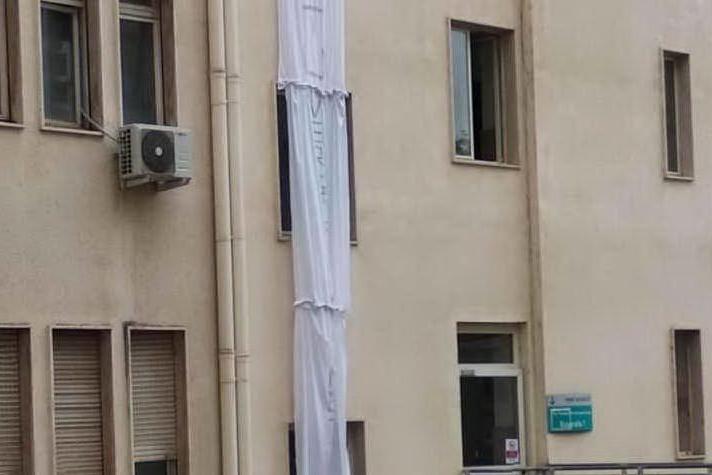 Lo striscione di protesta appeso stamattina all'ospedale Santissima Annunziata di Sassari (foto Tellini)