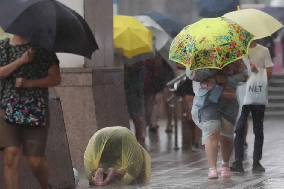 Persone sotto la pioggia a Taiwan (Ansa)