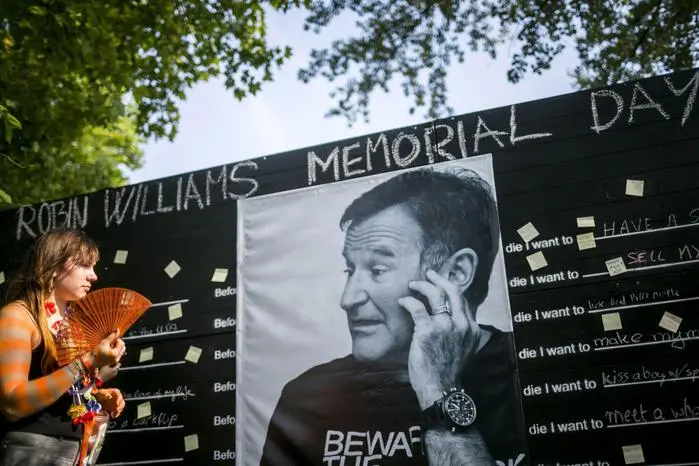 epa04354637 The image made available on 15 August 2014 shows a festival-goer paying tribute to US actor Robin Williams who died on 11 August at a makeshift memorial at the 22nd Sziget (Island) Festival on the Shipyard Island in northern Budapest, Hungary, 13 August 2014. The festival, one of the biggest cultural events of Europe offering art exhibitions, theatrical and circus performances and above all music concerts during a week runs until 18 August.  EPA/BALAZS MOHAI HUNGARY OUT