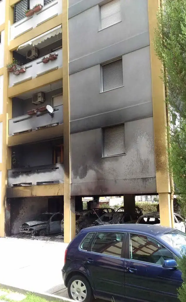 Le auto distrutte e l'edificio annerito dal fumo (foto del lettore Matteo Porcu)