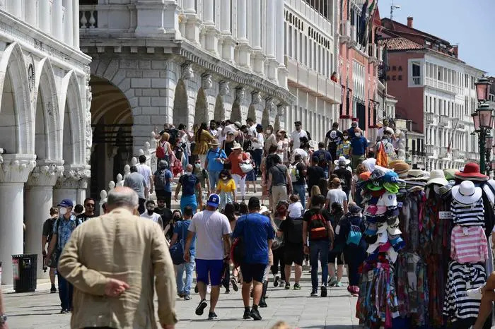 Turisti a Venezia (foto Ansa/Afp @Medina)