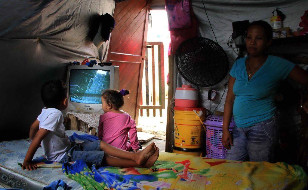 Una famiglia venezuelana alloggiata nelle baracche provvisorie di Barranquilla, in Colombia. (Foto Ansa)