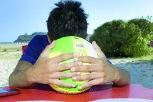 Uno dei ragazzi protagonisti della vicenda avvenuta lunedì al Poetto si nasconde dietro un pallone da beach volley [UNGARI)