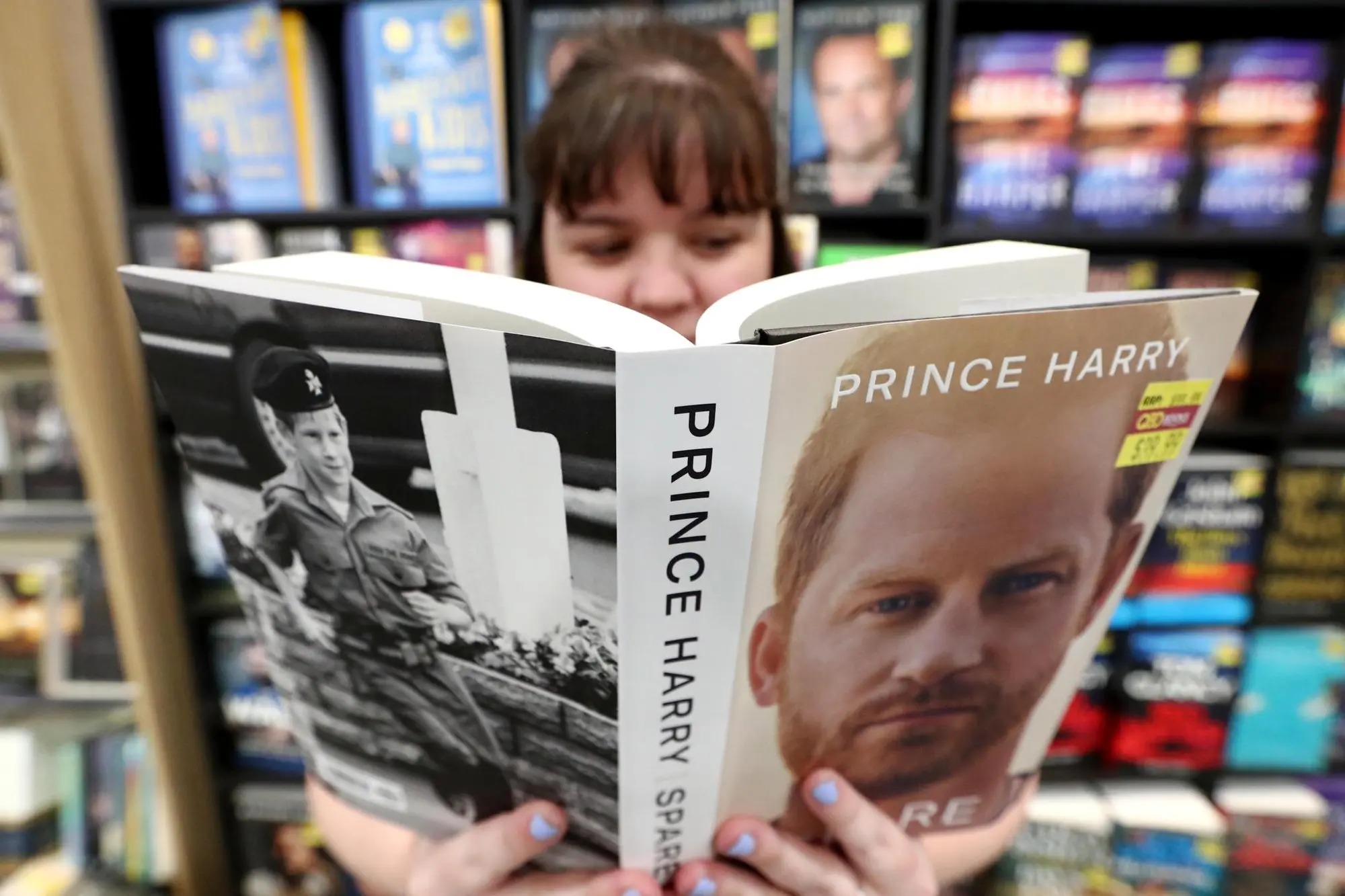 epa10399370 Prince Harry's memoir Spare is opened at a book store in Gold Coast, Australia, 11 January 2023. The publisher of the memoir says the book has become the United Kingdom's fastest selling non-fiction book ever. EPA/JASON O'BRIEN AUSTRALIA AND NEW ZEALAND OUT