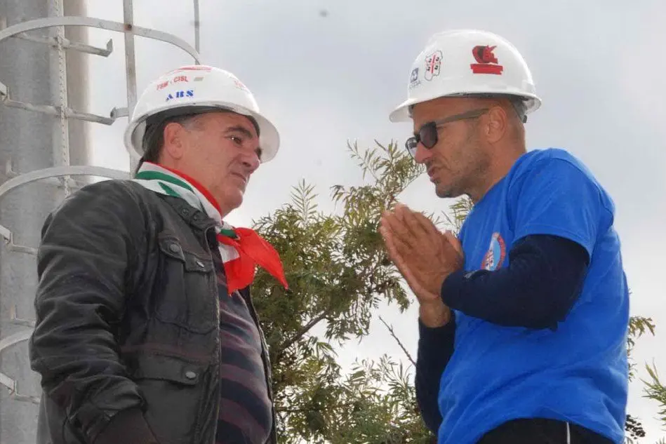 Andrea Mascia (a destra) mentre parla con un dipendente dell'ex Alcoa