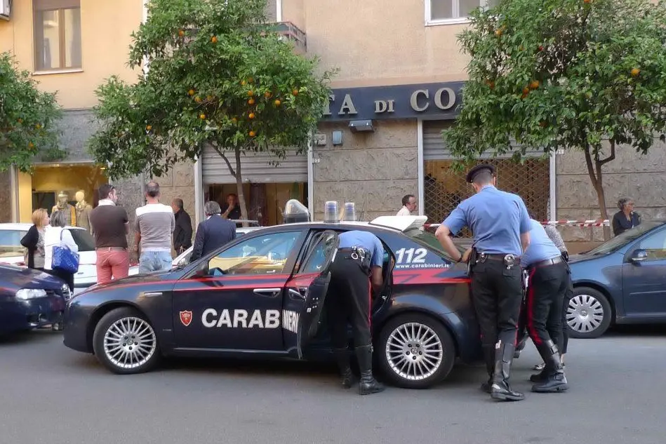 I carabinieri davanti al negozio di tessuti in cui è avvenuta la tragedia - foto Ungari
