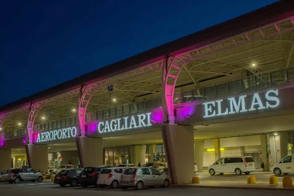 La facciata dell'aeroporto di Cagliari-Elmas illuminata di rosa