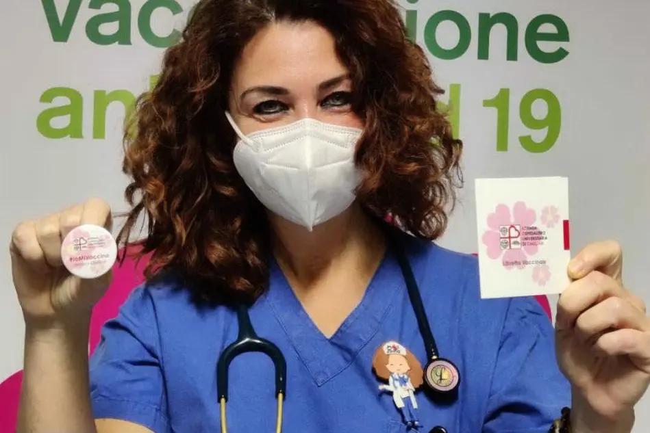 La dr.ssa Paola Neroni con libretto vaccinale e spilla (foto Uff. Stampa Policlinico di Monserrato)