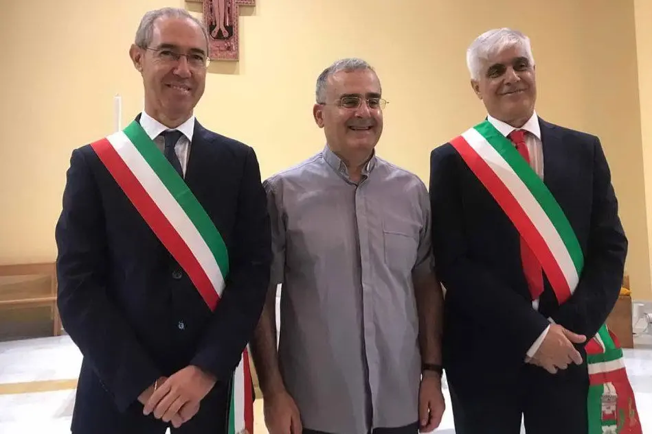 Don Gianni Locci tra il sindaco di Sarroch e quello di Capoterra (foto L'Unione Sarda - Murgana)