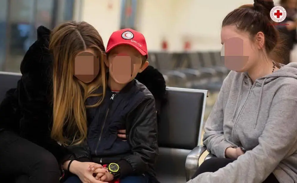 Alvin con le due sorelle che l'hanno accolto a Fiumicino (Ansa - Cri)