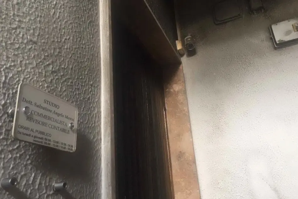 La porta danneggiata (foto L'Unione Sarda)