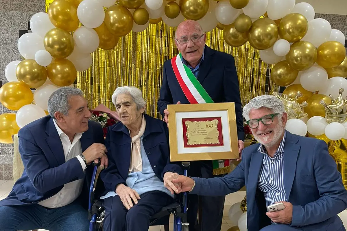 Il sindaco Siddi consegna alla nonnina la targa del Comune
