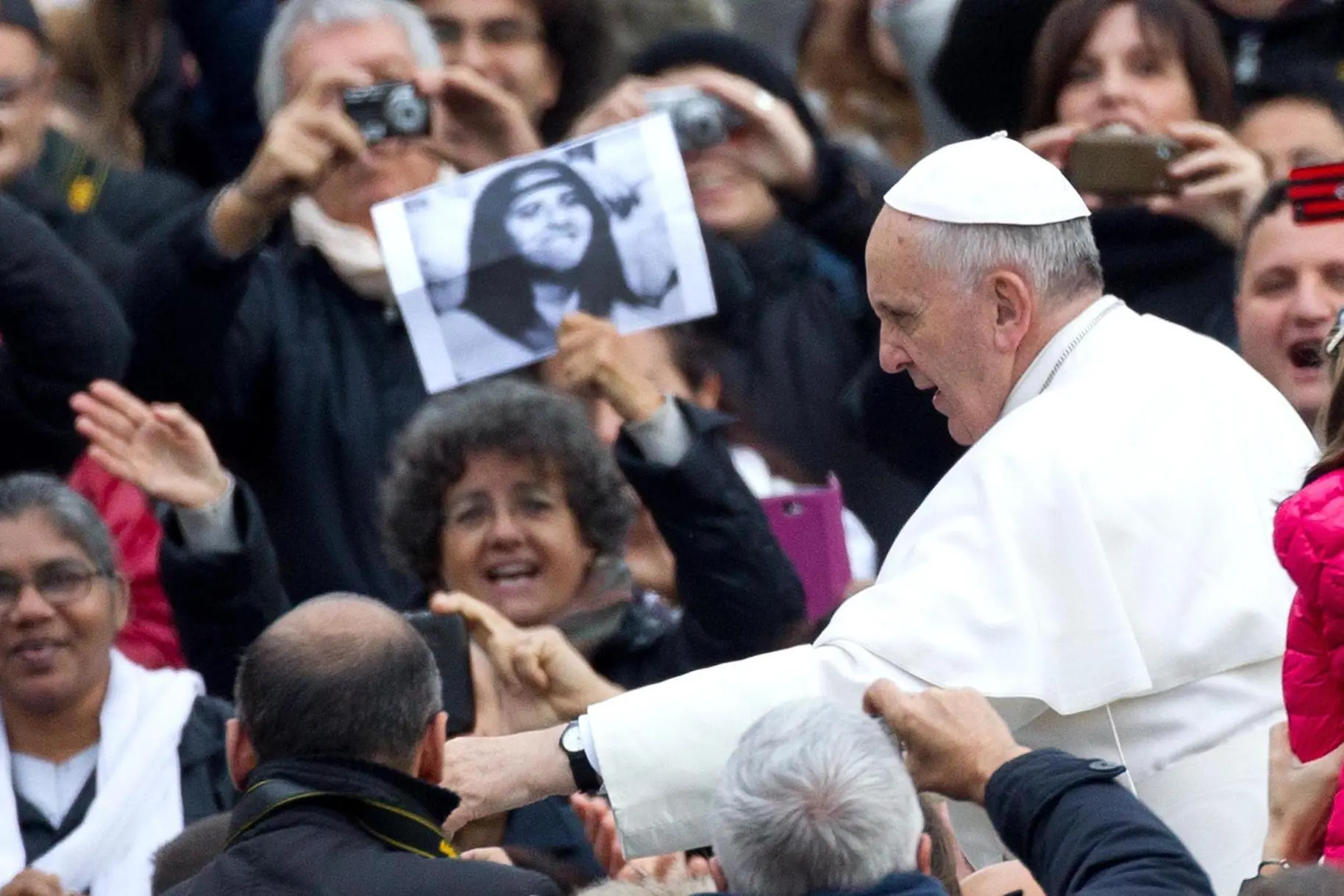 Pope Francis during Wednesday's General Audience in Saint Peter Square at the Vatican, 20 November 2013. Behind him people with pictures of Emanuela Orlandi. ANSA/CLAUDIO PERI