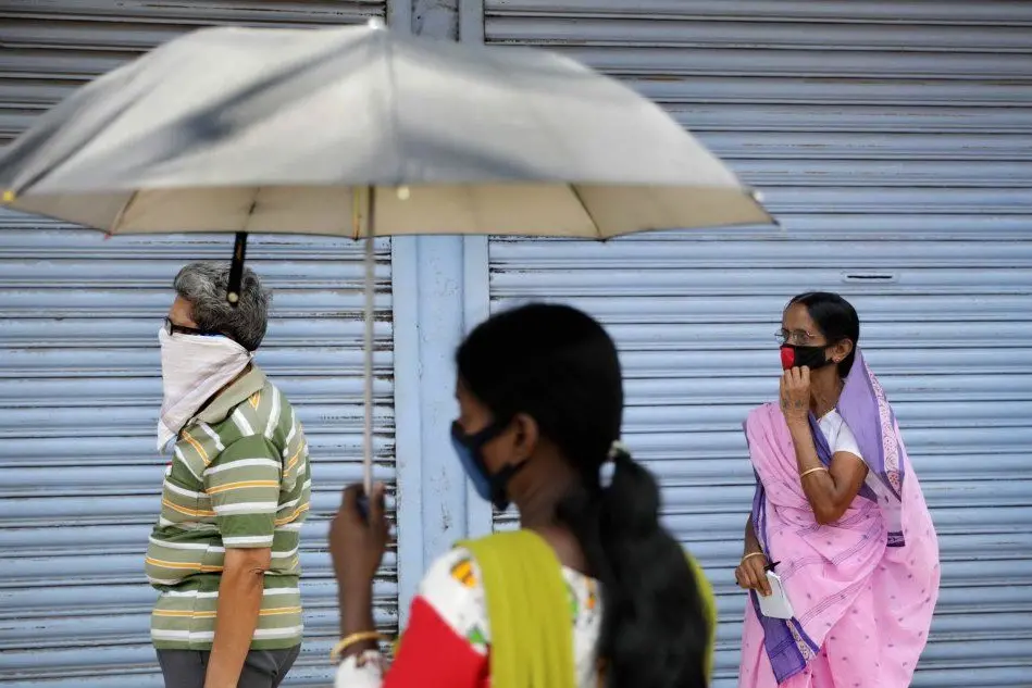 India, una donna e il suo ombrello protettivo (Ansa)