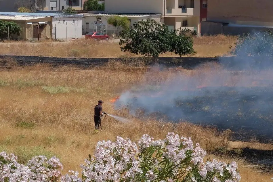 Un pompiere al lavoro per domare un incendio a Pirri
