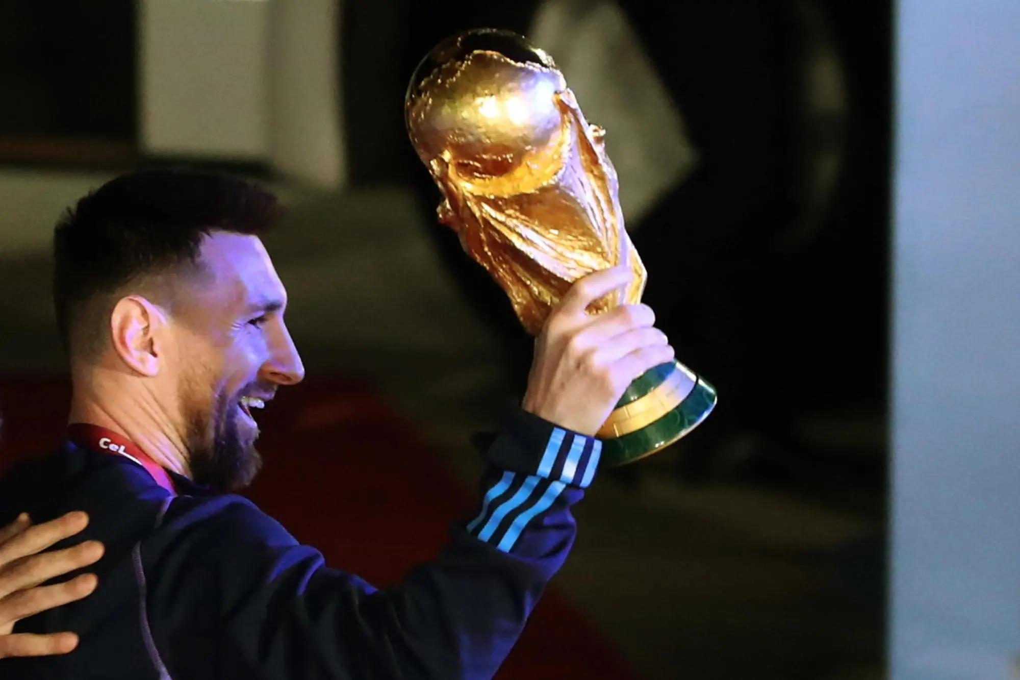 epa10374439 Lionel Messi of the Argentina national soccer team holds the trophy of Qatar 2022 World Cup upon the team's arrival to the International Airport of Ezeiza, some 22km of Buenos Aires, Argentina, 20 December 2022. EPA/RAUL MARTINEZ