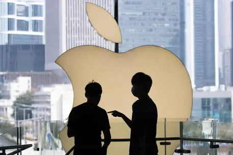 epa09825850 Apple Store staff talk in front of the Apple Inc. logo at the company’s store in Central, Hong Kong, China, 15 March 2022. Foxconn, the Taiwanese company and maker of Apple Inc.’ iPhone, has suspended iPhone factories in Shenzhen amid the COVID-19 lockdown of China’s southern tech hub. EPA/JEROME FAVRE