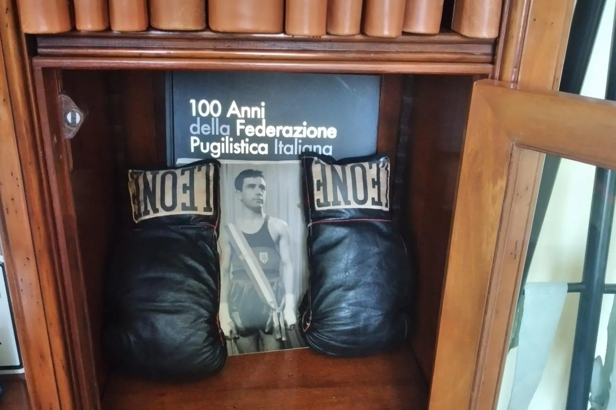 I guanti del campione Pino Mura nello studio del sindaco (foto Tellini) e Pino Mura contro Girgenti (foto concessa dalla famiglia)