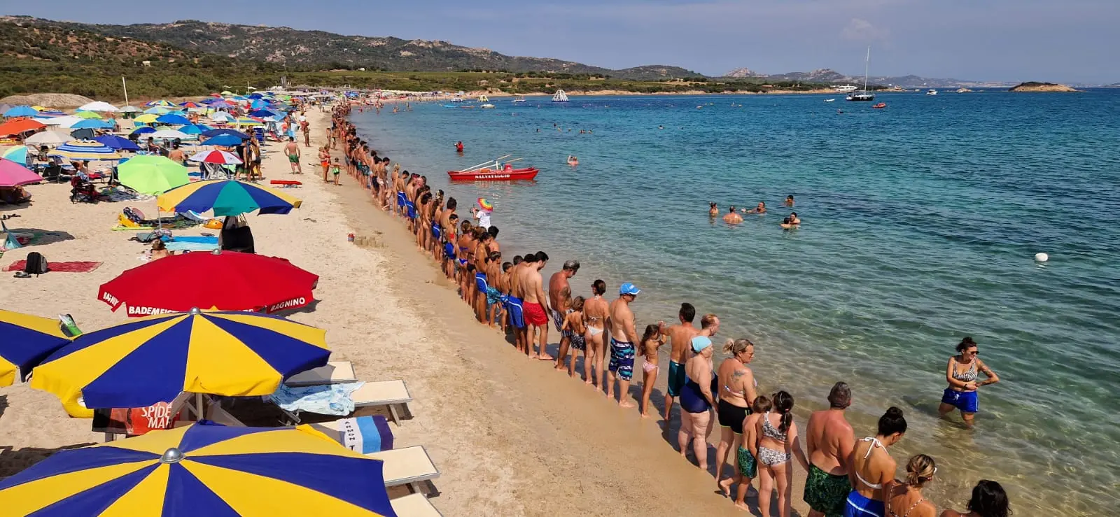 La catena umana in spiaggia a Cannigione