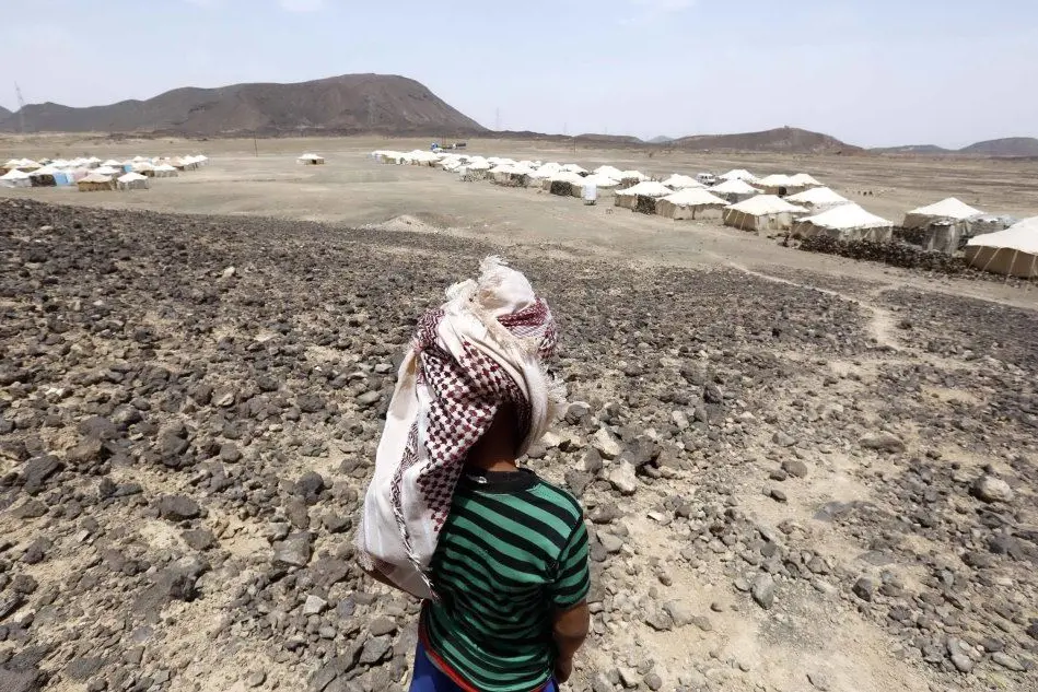 Un bimbo davanti a un campo profughi in Yemen (Ansa - Epa)