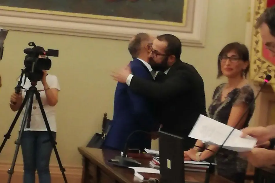 L'abbraccio fra uno dei detenuti, di spalle, e il professore dell'Università (foto Università di Sassari)