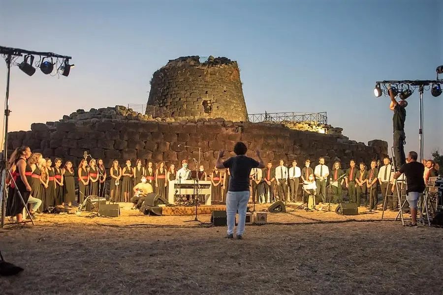 Le due corali del Maestro Cossu davanti alla Reggia Nuragica di Santu Antine (Foto Ufficio Stampa)