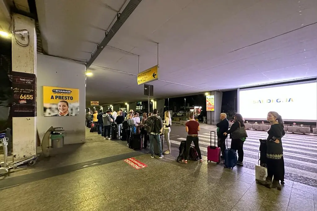 La fila fuori dall'aeroporto di Cagliari (foto L'Unione Sarda)