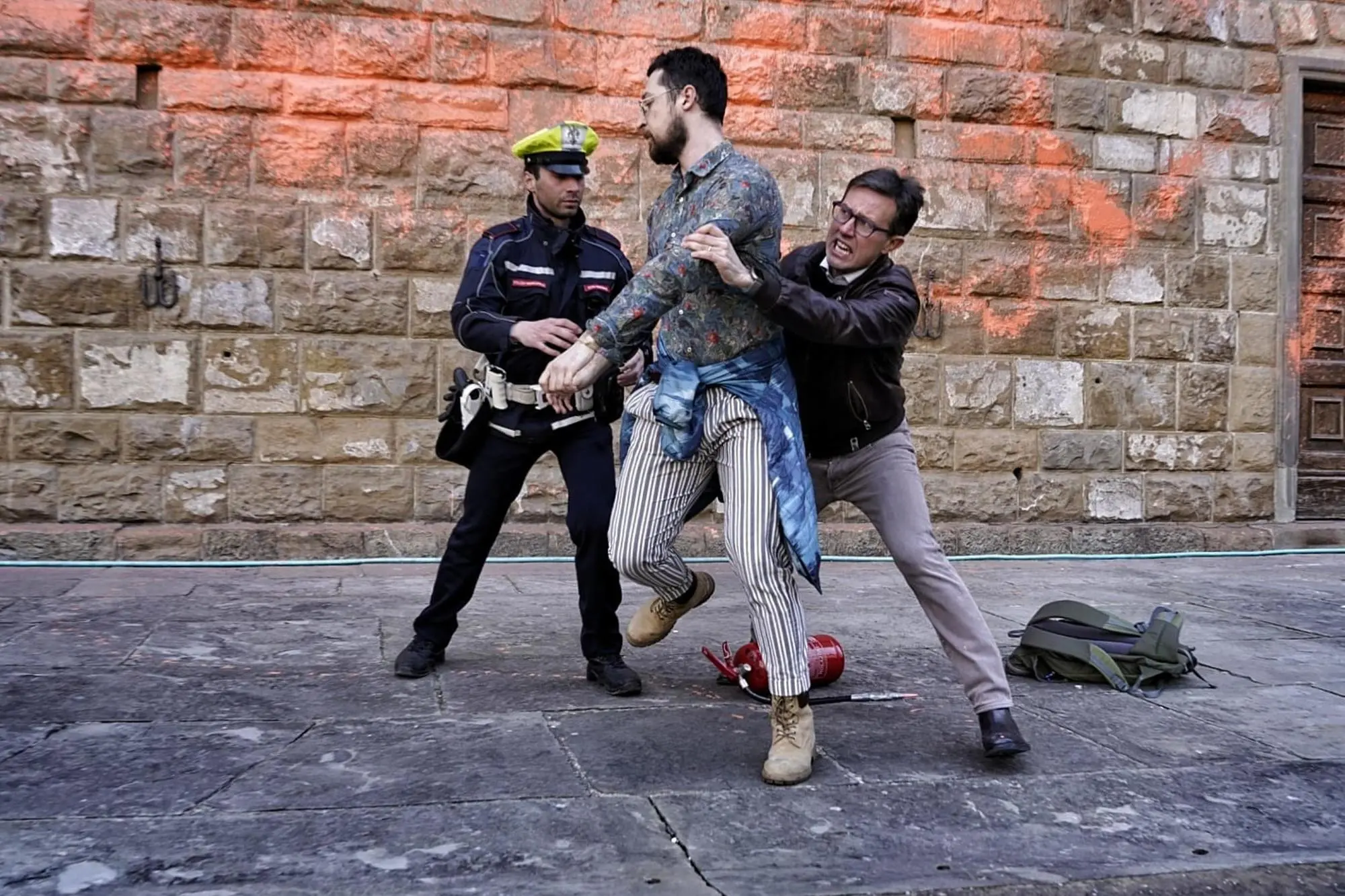 Il sindaco di Firenze Dario Nardella blocca uno degli attivisti ambientalisti che hanno imbrattato di vernice arancione la facciata di Palazzo Vecchio a Firenze a marzo 2023 (Ansa)