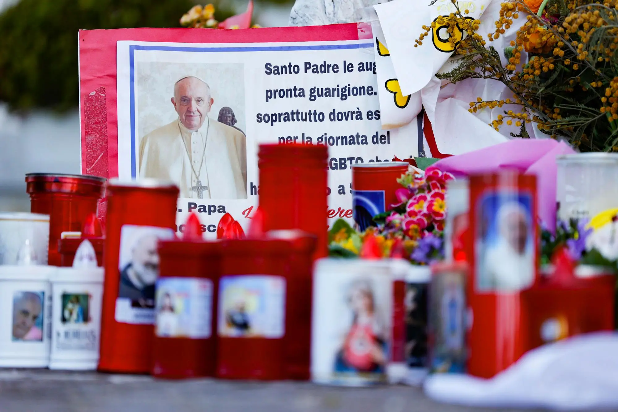 Fiori e candele per papa Francesco (Ansa)