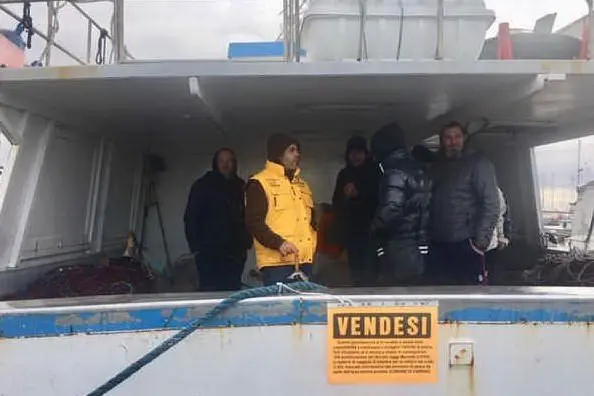 Alcuni dei pescatori sopra una barca (foto Sara Pinna)