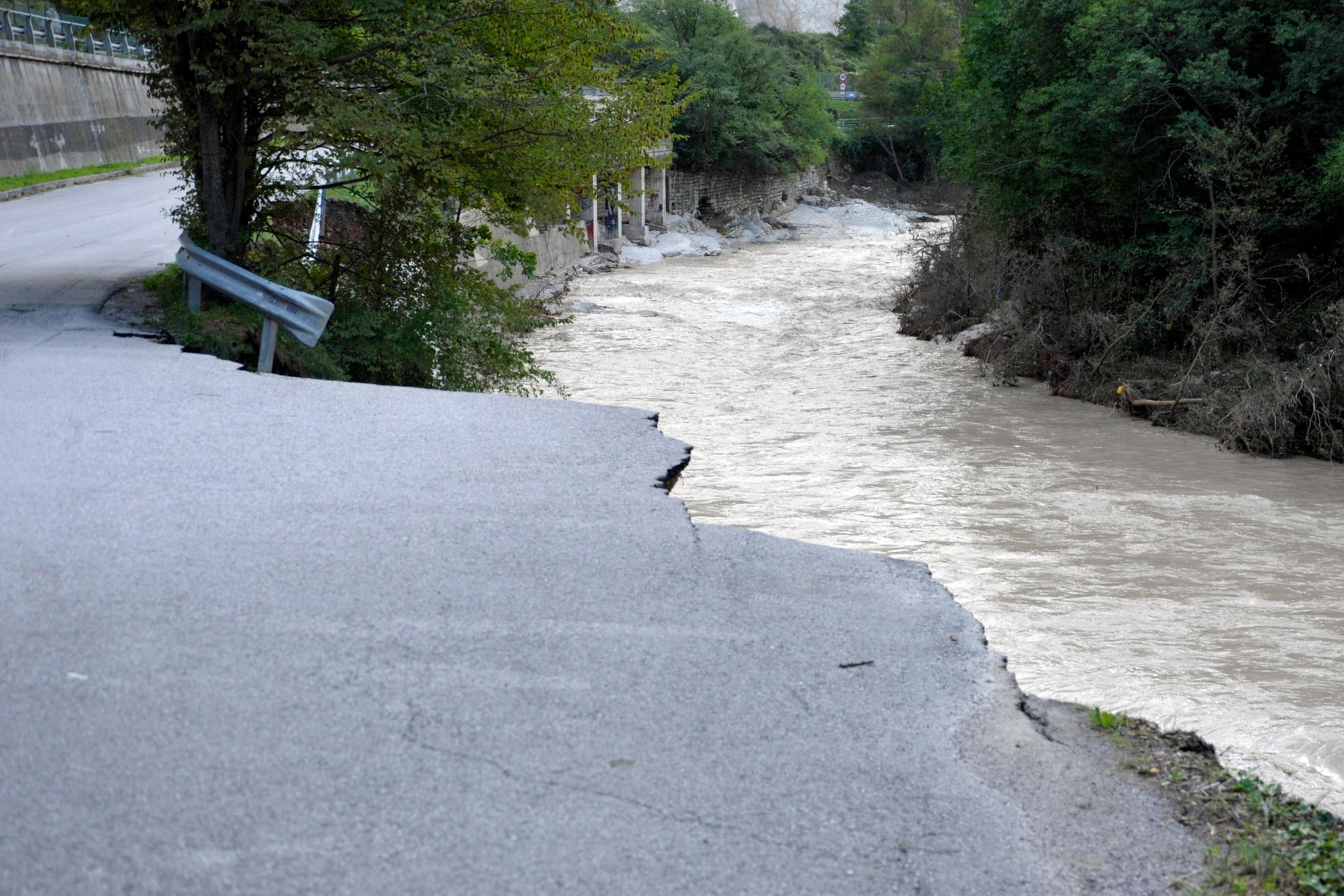 Una strada distrutta dall'alluvione nelle Marche (Ansa)