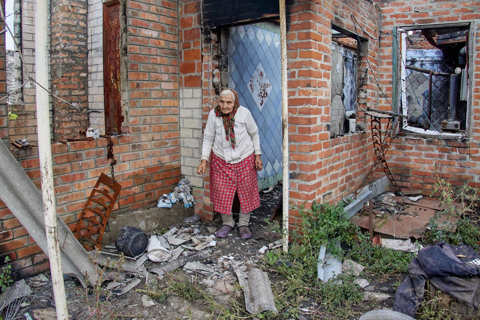 epaselect epa10218368 Nina Uspenskaya, stands next to her destroyed house following the Russian shelling, in the village of Korobochkyne, in the Kharkiv region, Ukraine, 01 October 2022. People in Ukraine are preparing for the winter season amid uncertainty over energy supplies. Kharkiv and surrounding areas have been the target of heavy shelling since February 2022, when Russian troops entered Ukraine starting a conflict that has provoked destruction and a humanitarian crisis. EPA/SERGEY KOZLOV