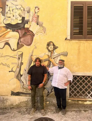 Cristiano De Andrè con il frontman degli Istentales, Gigi Sanna, davanti al murale del padre (Archivio L'Unione Sarda)