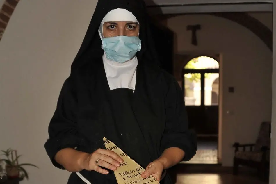 Suor Caterina mostra la targa ridotta in pezzi dai vandali (foto L'Unione Sarda - Chergia)