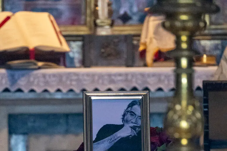 La foto in bianco e nero di Roberto Cavalli in chiesa (Ansa)