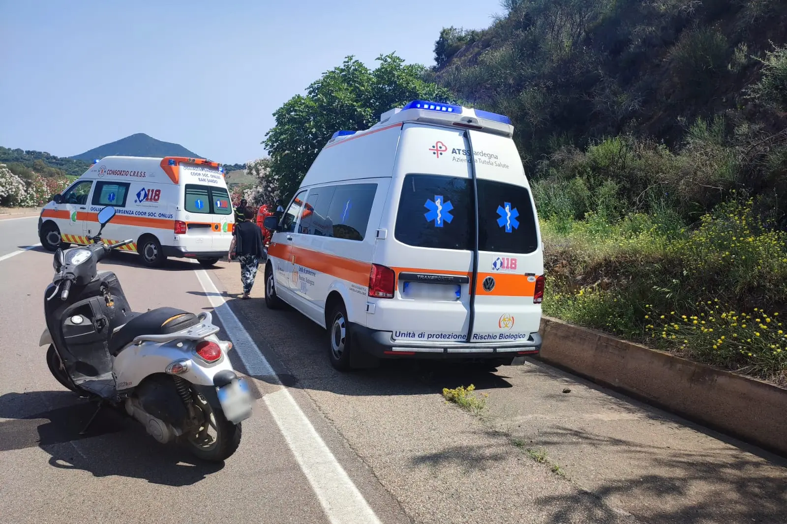 Lo scooter coinvolto nell'incidente e le ambulanze durante l'intervento (foto Secci)