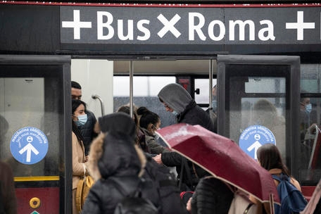 Utenti dei mezzi pubblici in attesa di prendere l'autobus presso gli stalli degli autobus in piazza dei Cinquecento a Roma, 29 novembre 2021. ANSA/CLAUDIO PERI