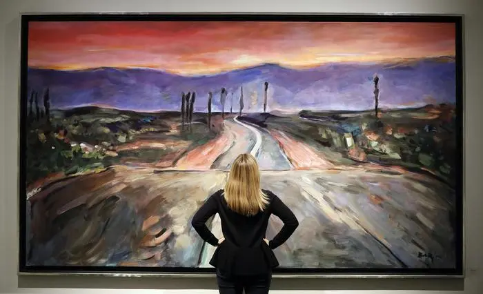 Una spettatrice davanti a un dipinto di Dylan intitolato &quot;Endless Highway&quot;