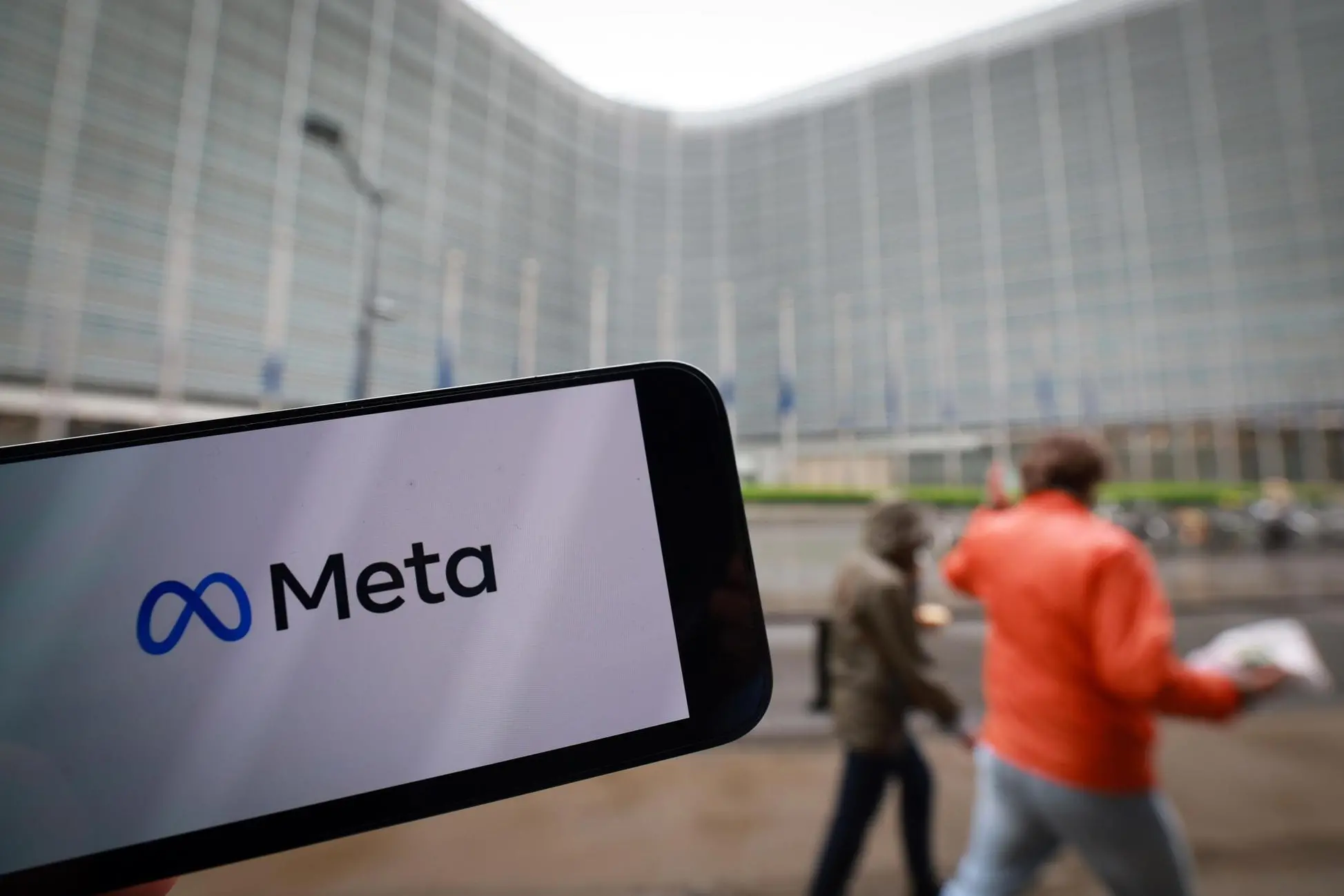 epa12048755 A Meta company logo on a phone in front of European Commission Headquarters as EU fines Apple 500 million Euro and Meta 200 million Euro for breaking Europe's digital rules in Brussels, Belgium, 23 April 2025. The European Commission on 23 April 2025 has fined Apple 500 million and Meta 200 million euros for breaching the Digital Markets Act (DMA). Apple was found to have breached its obligation to prevent anti-steering practices and Meta was found to have breached its obligation to offer consumers the choice of a service that uses less of their personal data. EPA/OLIVIER HOSLET