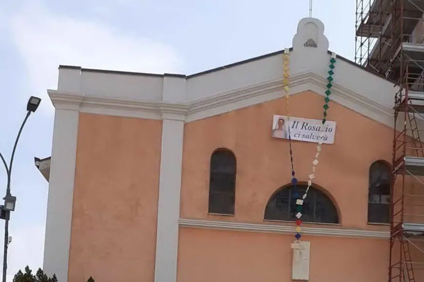 Il maxi-rosario calato dalla chiesa (Foto Secci)