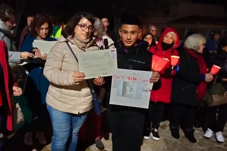 Ilaria Saladdino premia uno studente durante la fiaccolata (foto Pala)